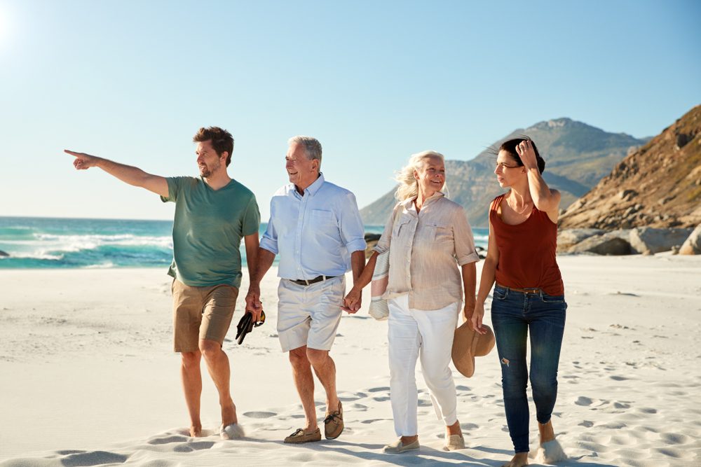 Mid,Adult,And,Senior,White,Couples,Walking,On,A,Beach
