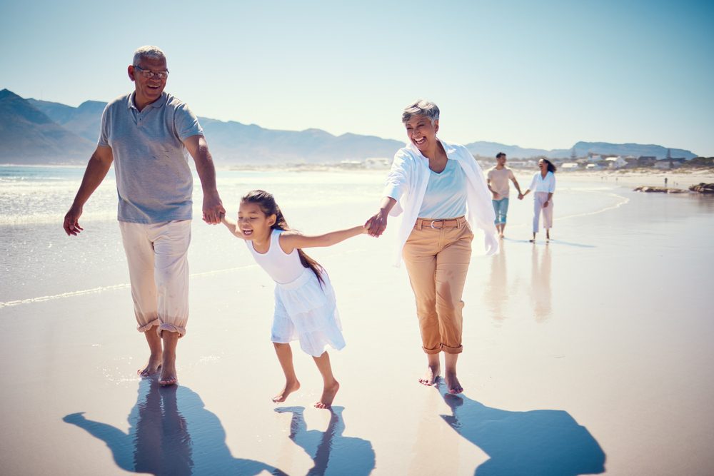 Beach,,Holding,Hands,And,Playing,,Grandparents,With,Girl,,Family,Walking