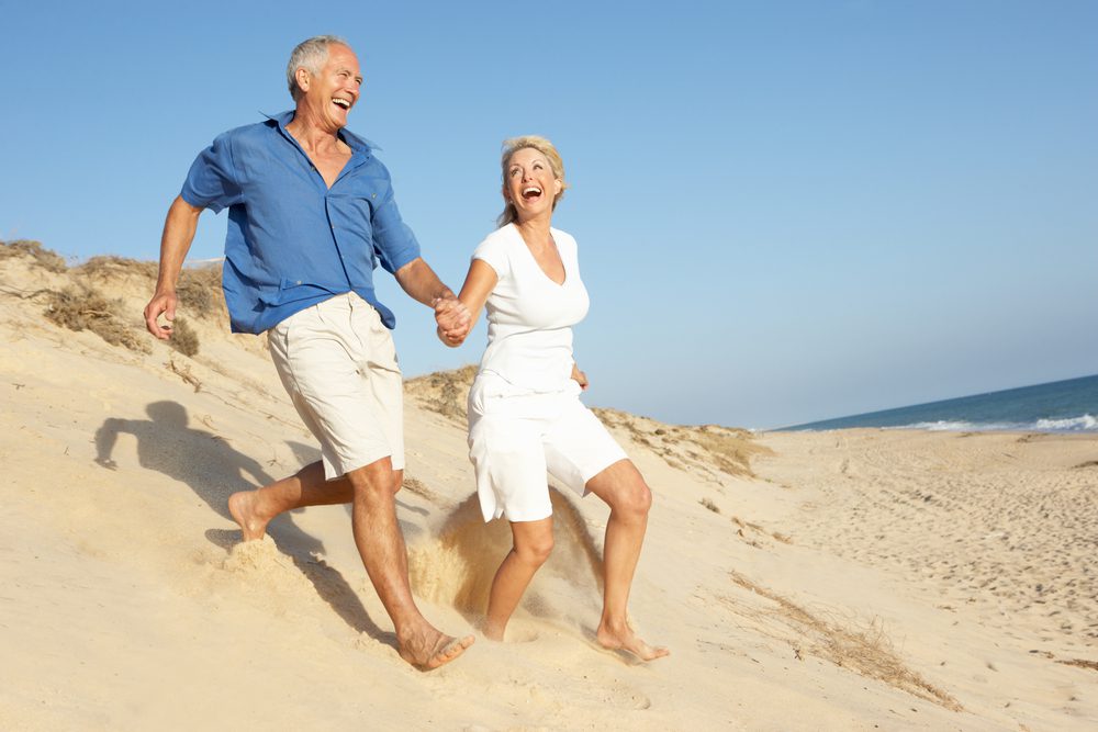 Senior,Couple,Enjoying,Beach,Holiday,Running,Down,Dune