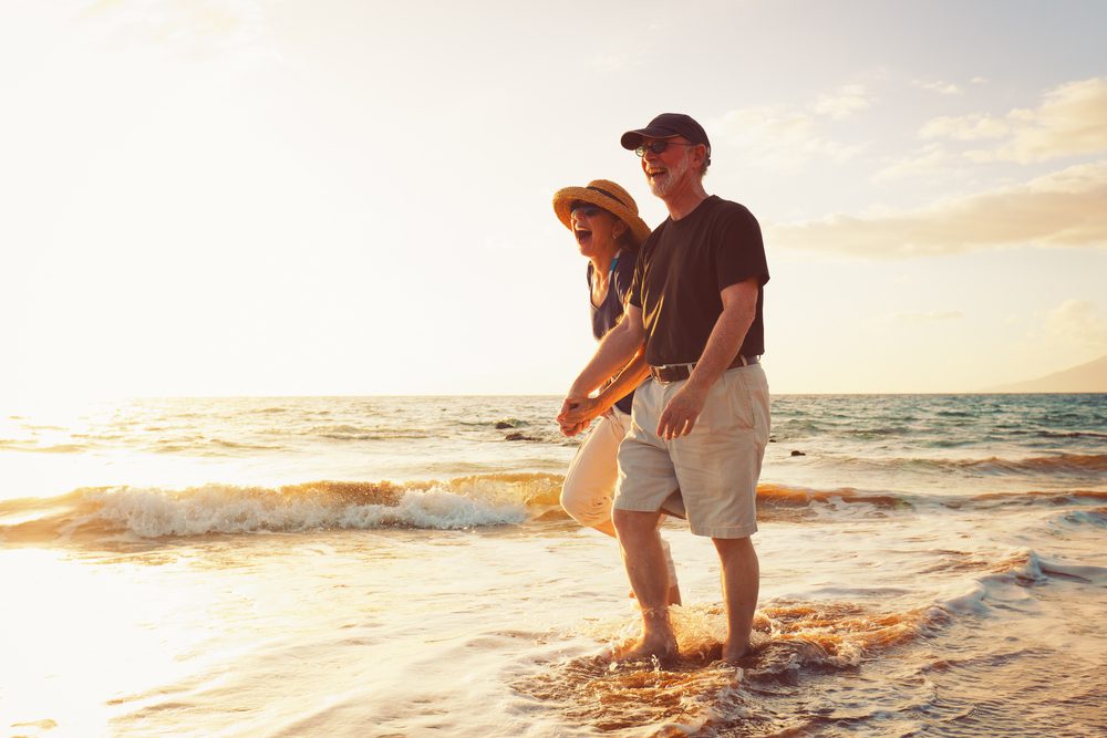 Senior,Couple,Enjoying,Sunset,At,The,Beach