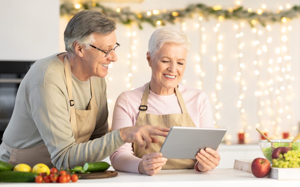 Happy,Senior,Couple,Cooking,Using,Digital,Tablet,Searching,Christmas,Recipes