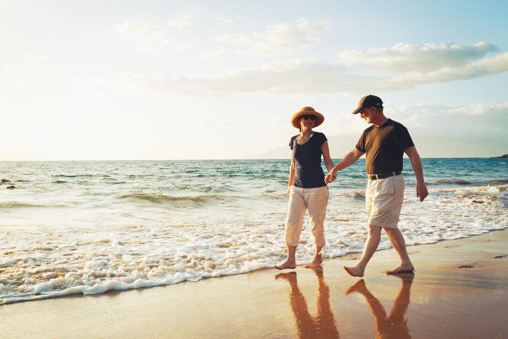 Senior,Couple,Enjoying,Sunset,At,The,Beach